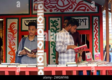 Dacca, Bangladesh. 6 febbraio 2024. I visitatori leggono libri alla fiera nazionale del libro chiamata Ekushey Boi Mela a Dacca. Ogni anno, la Bangla Academy organizza la fiera nazionale del libro nell'area dell'Università di Dhaka. Questa fiera del libro è la più grande del Bangladesh e si svolge per tutto il mese di febbraio. Dacca, Bangladesh, 6 febbraio 2024. Foto di Habibur Rahman/ABACAPRESS.COM credito: Abaca Press/Alamy Live News Foto Stock