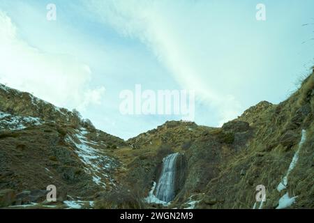 Kazbegi Stepantsminda confine tra Georgia e Russia. Cascata nella montagna e ghiacciai come sfondo Foto Stock