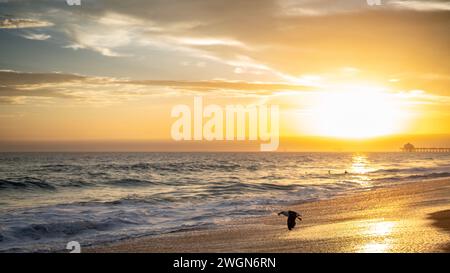 Un tramonto mozzafiato con un cielo pittoresco sopra Huntington Beach, California Foto Stock