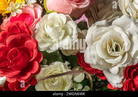 Splendidi fiori colorati artificiali come sfondo, primo piano. Foto Stock