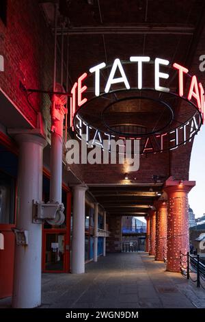Insegna della Tate Liverpool Art Gallery illuminata di notte presso Albert Dock, Liverpool, Merseyside, Foto Stock