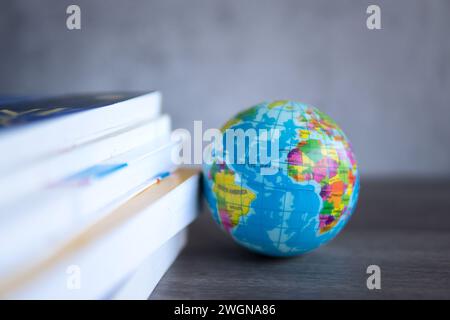 Pila di immagini da vicino di libri con un globo su un tavolo di legno. Copia spazio per il testo. Giornata mondiale del libro, educazione e concetto di conoscenza. Foto Stock