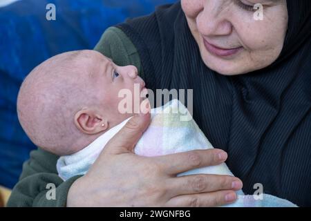 Nonna che tiene il nipotino sorridente e si sente felice Foto Stock