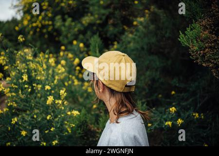 Ritratto di una giovane donna escursionista con un cappello giallo nella foresta Foto Stock