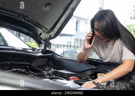 Hai bisogno di aiuto con il guasto dell'auto donna seria ascolta i consigli e la spiegazione del servizio di riparazione auto di emergenza al telefono. Foto Stock