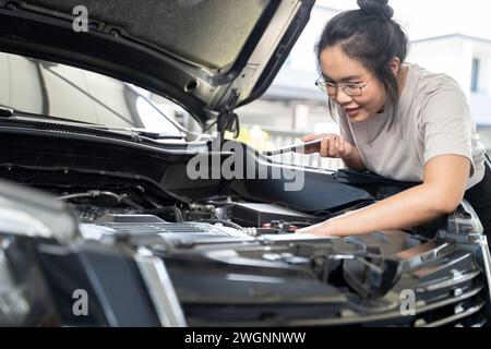 Hai bisogno di aiuto con il guasto dell'auto donna seria ascolta i consigli e la spiegazione del servizio di riparazione auto di emergenza al telefono. Foto Stock