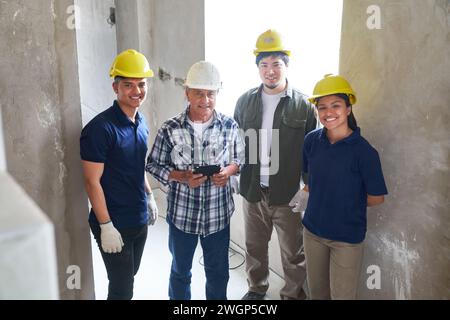 Appaltatore senior con lavoratori che indossano indumenti Foto Stock