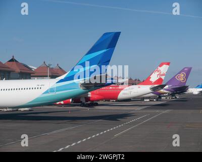 Denpasar, Indonesia - 21 ottobre 2017: Aerei di coda di Garuda Indonesia e Air Asia X Airbus A330 e Thai Airways Boeing 747 presso i gusti Ngurah Rai Foto Stock