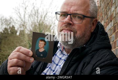 Stephen Lewsey ha una foto di sé stesso da giovane durante un'intervista con PA Media, presso la sede della polizia del Sussex a Lewes, dopo che ha rinunciato al suo diritto all'anonimato per incoraggiare altre vittime di abusi a farsi avanti. Il violentatore del signor Lewsey, Glenn Langrish, noto anche come Glenn Stephens, è stato incarcerato per 15 anni alla Corte di giustizia di Hove per i suoi crimini risalenti agli anni '1980, dopo essere stato oggetto di una caccia all'uomo internazionale per 12 anni. Data foto: Martedì 6 febbraio 2024. Foto Stock