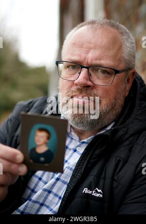 Stephen Lewsey ha una foto di sé stesso da giovane durante un'intervista con PA Media, presso la sede della polizia del Sussex a Lewes, dopo che ha rinunciato al suo diritto all'anonimato per incoraggiare altre vittime di abusi a farsi avanti. Il violentatore del signor Lewsey, Glenn Langrish, noto anche come Glenn Stephens, è stato incarcerato per 15 anni alla Corte di giustizia di Hove per i suoi crimini risalenti agli anni '1980, dopo essere stato oggetto di una caccia all'uomo internazionale per 12 anni. Data foto: Martedì 6 febbraio 2024. Foto Stock