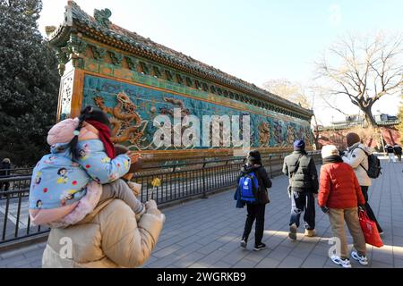 (240206) -- PECHINO, 6 febbraio 2024 (Xinhua) -- le persone visitano il muro dei nove draghi al Parco Beihai a Pechino, capitale della Cina, 24 gennaio 2024. Creata per la prima volta durante la dinastia Yuan (1271-1368), l'asse centrale di Pechino, o Zhongzhouxian, si estende per 7,8 chilometri tra la porta di Yongding nel sud della città e la Torre del tamburo e la torre campanaria nel nord. Porte, palazzi, templi, piazze e giardini della città vecchia sono tutti collegati all'asse. All'avvicinarsi della Festa di Primavera dell'anno del Drago, molti elementi festivi con il tema del "drago" sono stati avvistati sull'asse di Beijin Foto Stock