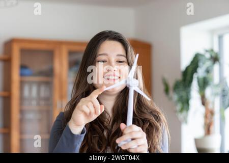 giovane donna che gioca con un mulino a vento a casa Foto Stock