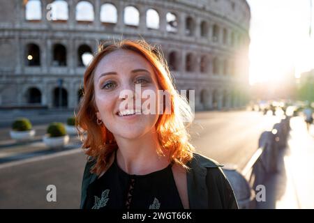 Giovane donna dai capelli rossi, vicino al Colluseo, Roma, Italia Foto Stock