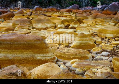 I caldi depositi minerali arancioni del Rio Tinto scolpiscono un paesaggio strutturato con pozzanghere riflettenti Foto Stock