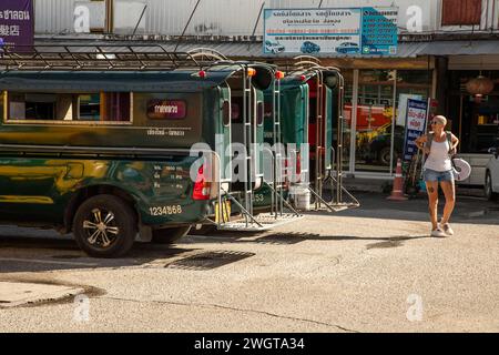 Donna di mezza età, viaggiatore solo si trova in una stazione degli autobus nel nord della Thailandia Foto Stock