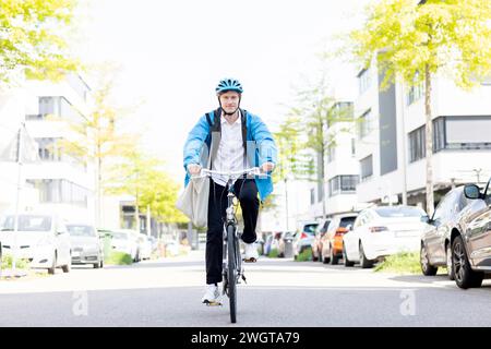 Giovane in bicicletta in città con il casco Foto Stock