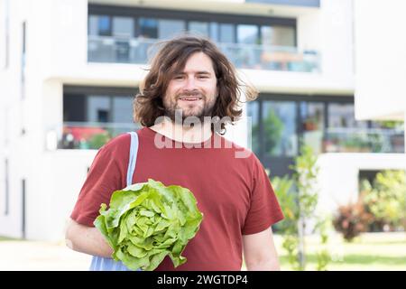 giovane con una borsa che vende un'insalata e torna a casa in città Foto Stock