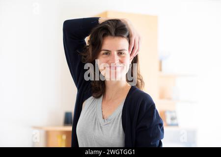 giovane donna in piedi in una stanza, sorridente Foto Stock