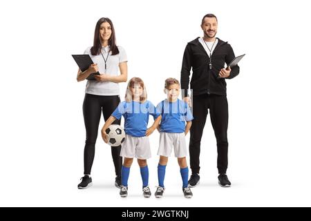 Allenatori di calcio con bambini in divise in posa e che guardano la telecamera isolata su sfondo bianco Foto Stock