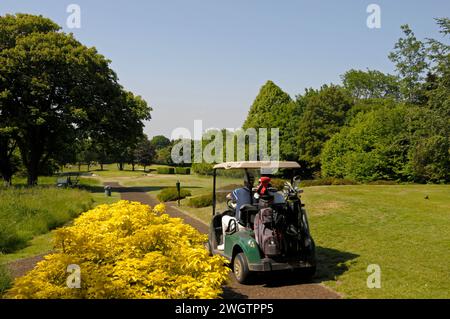 Vista dall'8th Tee con golfista in buggy in direzione Green, Woodcote Park Golf Club, Coulsdon, Surrey, Inghilterra Foto Stock