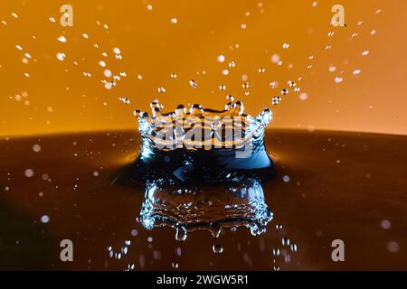 Gocce d'acqua Crown con sfondo dorato, vista laterale ad alta velocità Foto Stock