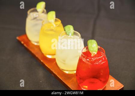 Rinfrescanti bevande estive su vassoio di legno con contorno al lime Foto Stock