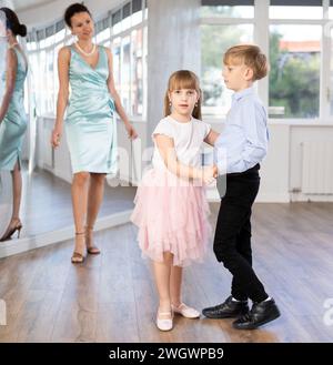 Ballerini Tween, ragazza e ragazzo che praticano il valzer in uno studio di danza Foto Stock
