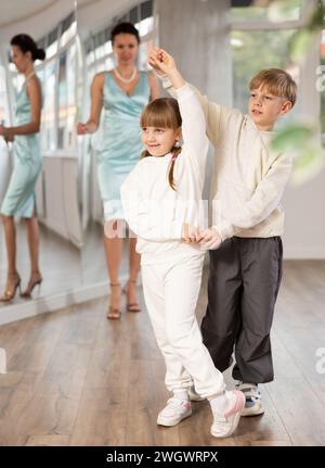 Ballerini Tween, ragazza e ragazzo che praticano il valzer in uno studio di danza Foto Stock