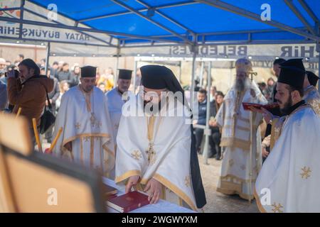 Hatay, Turchia. 6 febbraio 2024. Un prete prende un libro della bibbia araba per scegliere un inno durante la messa. La Chiesa greco-ortodossa di Antiochia, fondata negli anni '1800, tenne una messa per coloro che persero la vita nel terremoto del 6 dicembre. Mentre gli inni venivano cantati in turco, arabo e latino per i morti, molte persone parteciparono al servizio nelle rovine delle chiese distrutte dal terremoto. Credito: SOPA Images Limited/Alamy Live News Foto Stock