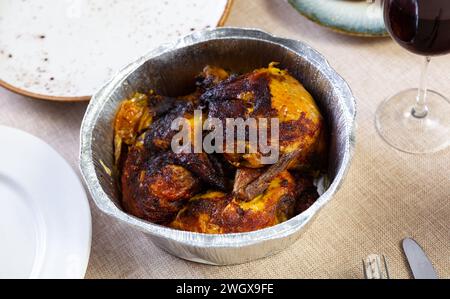 in un piatto da forno in lamina di pollo intero cotto al forno con crosta fritta croccante Foto Stock