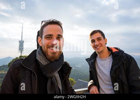 Vista ravvicinata grandangolare di due ingegneri di una centrale elettrica sorridenti alla telecamera Foto Stock