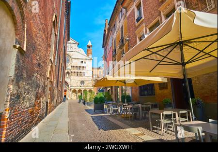 La stretta via dei Gonfalonieri con piccoli ristoranti e vista sulla Cattedrale di Cremona, Italia Foto Stock