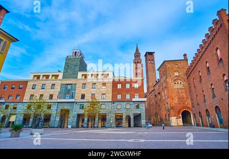 Piazza Stradivari (Piazza Cavour) con edifici storici e moderni e Torrazzo, campanile del Duomo di Cremona sullo sfondo, Italia Foto Stock