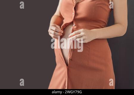 Nessun problema con il fissaggio. Scegli un abito maternità che offra comfort e stile alla tua pancia incinta Foto Stock