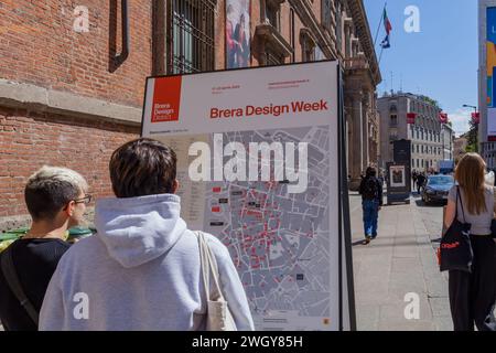 MILANO, ITALIA - 04 17 2023: Visitatori che osservano la mappa della settimana del design nel quartiere Brera nel centro storico di Milano Foto Stock