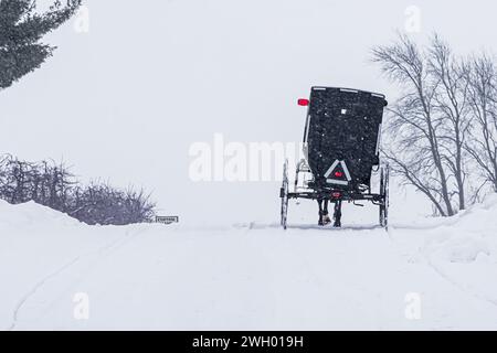 Calesse Amish su una strada innevata in inverno nella contea di Mecosta, Michigan, Stati Uniti Foto Stock