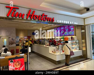 Pechino, Cina. 8 dicembre 2023. I clienti entrano in un negozio Tim Hortons nel centro di Pechino l'8 dicembre 2023. Il licenziatario di Tim Hortons, con sede a Shanghai, gestisce più di 675 negozi del famoso caffè canadese e ciambelle in Cina. (Foto di Samuel Rigelhaupt/Sipa USA) credito: SIPA USA/Alamy Live News Foto Stock