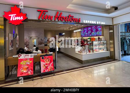 Pechino, Cina. 8 dicembre 2023. I clienti entrano in un negozio Tim Hortons nel centro di Pechino l'8 dicembre 2023. Il licenziatario di Tim Hortons, con sede a Shanghai, gestisce più di 675 negozi del famoso caffè canadese e ciambelle in Cina. (Foto di Samuel Rigelhaupt/Sipa USA) credito: SIPA USA/Alamy Live News Foto Stock