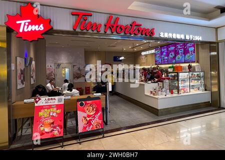 Pechino, Cina. 8 dicembre 2023. I clienti entrano in un negozio Tim Hortons nel centro di Pechino l'8 dicembre 2023. Il licenziatario di Tim Hortons, con sede a Shanghai, gestisce più di 675 negozi del famoso caffè canadese e ciambelle in Cina. (Foto di Samuel Rigelhaupt/Sipa USA) credito: SIPA USA/Alamy Live News Foto Stock