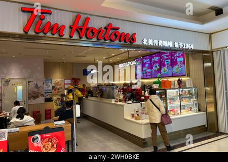 Pechino, Cina. 8 dicembre 2023. I clienti entrano in un negozio Tim Hortons nel centro di Pechino l'8 dicembre 2023. Il licenziatario di Tim Hortons, con sede a Shanghai, gestisce più di 675 negozi del famoso caffè canadese e ciambelle in Cina. (Foto di Samuel Rigelhaupt/Sipa USA) credito: SIPA USA/Alamy Live News Foto Stock