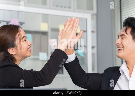 Messa a fuoco al tatto delle mani. Gruppo di persone d'affari del sud-est asiatico che lavorano in concetto di ufficio. Giovane donna d'affari adulta e uomo insieme per il successo faccia felice sorriso. Foto Stock
