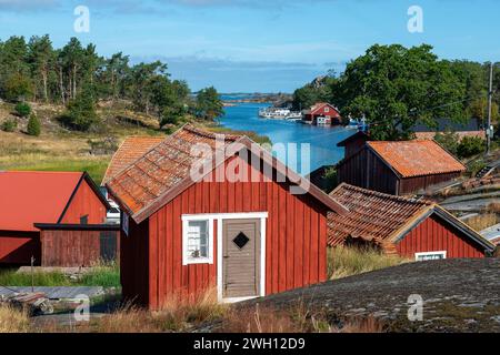 Estate in Svezia. Tradizionali capanne da pesca rosso falu ad Harstena, un'isola sulla costa orientale della Svezia nel Mar Baltico Foto Stock