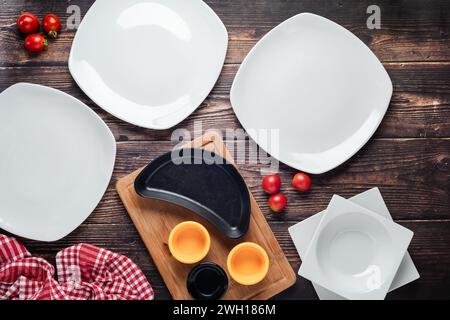 Vista dall'alto dei piatti vuoti con verdure intorno a loro su un tavolo di legno Foto Stock