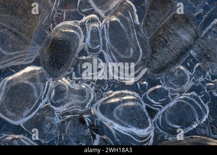 Ghiaccio con bolle d'aria intrappolate, colpo ravvicinato, acqua congelata orizzontale. Foto Stock