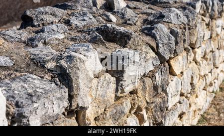 Un primo piano di un antico muro di pietra romano Foto Stock