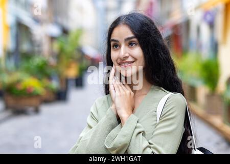 Una bella giovane donna indiana gode di una piacevole passeggiata attraverso la città, incarnando lo spirito del turismo urbano e dell'esplorazione. Foto Stock