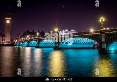 Londra. REGNO UNITO- 02.04.2024. Una vista notturna del Ponte di Westminster con Big Ben alla fine e riflessi di luce sul Tamigi. Foto Stock