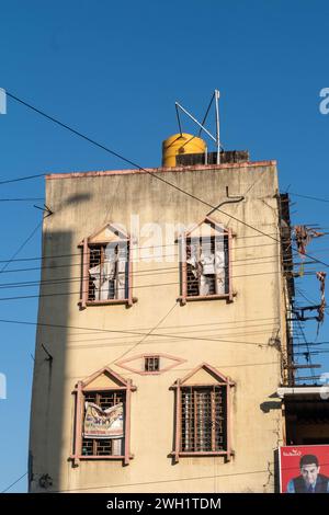 Hassan, Karnataka, India - 10 gennaio 2023: Un edificio urbano intempestivo, caratterizzato da un'importante vasca d'acqua gialla, viene catturato contro un cielo blu brillante, Foto Stock