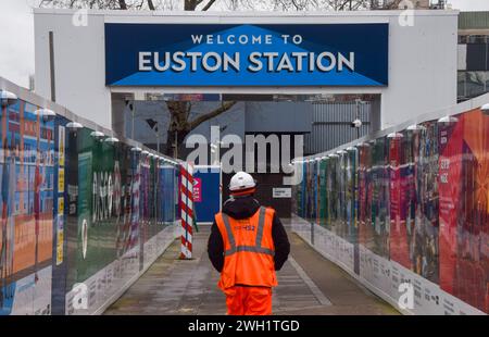 Londra, Regno Unito. 7 febbraio 2024. Un lavoratore passa accanto al cantiere HS2 presso la stazione di Euston, come i parlamentari avvertono che la ferrovia ad alta velocità sarà “molto scadente dal punto di vista economico”. Il progetto da miliardi di sterline è stato afflitto da costi vertiginosi e numerosi problemi. Crediti: Vuk Valcic/Alamy Live News Foto Stock