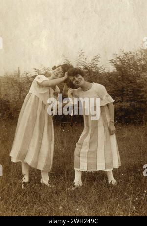 Due ragazze vestite allo stesso modo giocando fuori, Italia 1921 Foto Stock